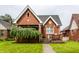 Charming brick home with a well-manicured lawn and a beautiful weeping willow tree at 948 N Layman Ave, Indianapolis, IN 46219