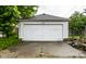 A detached one car garage with asphalt driveway and manicured lawn on an overcast day at 948 N Layman Ave, Indianapolis, IN 46219