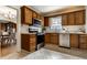 Kitchen featuring stainless steel appliances, tile flooring, wood cabinets and a view into an adjacent dining area at 948 N Layman Ave, Indianapolis, IN 46219