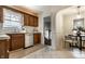 Cozy kitchen with wood cabinetry, a stainless steel dishwasher, and a view into the adjacent dining nook at 948 N Layman Ave, Indianapolis, IN 46219