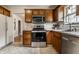 A kitchen with wood cabinetry, stainless steel appliances and a tile floor at 948 N Layman Ave, Indianapolis, IN 46219