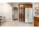 Kitchen with wood cabinets, white refrigerator, and a view of the dining area through an arched doorway at 948 N Layman Ave, Indianapolis, IN 46219