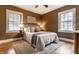 A comfortably decorated primary bedroom with hardwood floors, a ceiling fan, and two large windows at 948 N Layman Ave, Indianapolis, IN 46219