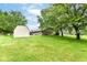 View of the home's backyard with a shed and trees lining the well-manicured lawn at 9608 Sycamore Rd, Carmel, IN 46032