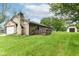 Exterior view displaying a shed and a stone chimney set against a lush green lawn at 9608 Sycamore Rd, Carmel, IN 46032