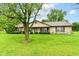 Charming stone-clad ranch home featuring a spacious front yard with mature trees and lovely landscaping at 9608 Sycamore Rd, Carmel, IN 46032