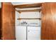 Washer and dryer hookups inside open closet with wood door at 9608 Sycamore Rd, Carmel, IN 46032