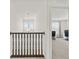 Bright upstairs hallway featuring modern railing and view of bonus room with natural light from large windows at 1026 Sorrell Pass, Greenwood, IN 46143
