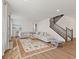 Bright living room with a large gray sectional couch, decorative rug and staircase at 1026 Sorrell Pass, Greenwood, IN 46143