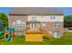 Exterior view of the home featuring a wooden deck, brick facade, playset, and lush green lawn for outdoor enjoyment at 10555 Serra Vista Pt, Fishers, IN 46040