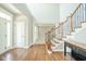 Foyer with hardwood floors, staircase with ornamental iron and view to living room at 10555 Serra Vista Pt, Fishers, IN 46040