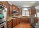 Well-lit kitchen with wood cabinets, granite countertops, stainless steel appliances, and hardwood floors at 10555 Serra Vista Pt, Fishers, IN 46040