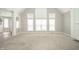 Bright living room with tall windows, neutral paint, and plush carpet flooring at 10555 Serra Vista Pt, Fishers, IN 46040
