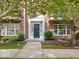 Charming red brick home featuring a black front door with white trim and manicured landscaping at 11509 Reagan Dr, Fishers, IN 46038