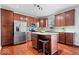 Kitchen features stainless steel appliances, dark wood cabinets, an island, and hardwood floors at 11509 Reagan Dr, Fishers, IN 46038