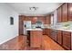 Well-lit kitchen featuring stainless steel appliances, dark wood cabinets, island with seating, and hardwood floors at 11509 Reagan Dr, Fishers, IN 46038
