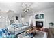 Cozy living room featuring a fireplace, gray sofa with patterned pillows, and dark hardwood floors at 11509 Reagan Dr, Fishers, IN 46038