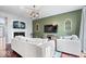 Cozy living room featuring a fireplace, gray sofas, hardwood floors, green accent wall, and stylish lighting at 11509 Reagan Dr, Fishers, IN 46038