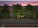 Lovely townhomes with brick exteriors, mature trees, and well-maintained landscaping at dusk at 11509 Reagan Dr, Fishers, IN 46038