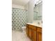 Well-lit bathroom with wood vanity, marble floors, tub, shower and neutral patterned curtain at 1176 Everton Ct, Greenwood, IN 46143