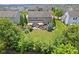 Aerial view of a backyard with lush greenery, patio with furniture, and a built-in grill at 1294 Vista Way, Greenwood, IN 46143