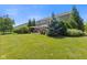 Well-maintained backyard with green lawn, established trees, and a patio with outdoor seating and a grill at 1294 Vista Way, Greenwood, IN 46143