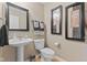 Charming powder room with pedestal sink, decorative mirror, and wall art at 1294 Vista Way, Greenwood, IN 46143