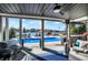 Entertainers back patio view overlooking lake with covered pool and outdoor seating at 13613 Lake Ridge Ln, McCordsville, IN 46055
