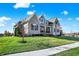 A well-manicured lawn and landscaping surround this beautiful two-story home with a stone and siding exterior at 13613 Lake Ridge Ln, McCordsville, IN 46055