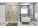 Bright main bathroom with marble-look tile, large shower, and stand alone tub at 13613 Lake Ridge Ln, McCordsville, IN 46055