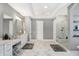 Bright main bathroom with double vanity sinks, makeup vanity, shower with glass door, and marble flooring at 13613 Lake Ridge Ln, McCordsville, IN 46055