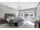 Bright main bedroom boasts trey ceiling, pendant lighting, waterfront views from large windows, and a gray upholstered bed at 13613 Lake Ridge Ln, McCordsville, IN 46055