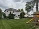 Expansive backyard featuring a well-maintained lawn, playset, and a wooden deck with a pergola at 1378 Runningbrook Dr, Avon, IN 46123