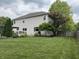 Spacious backyard with lush green grass, a wooden deck, and mature trees for added privacy at 1378 Runningbrook Dr, Avon, IN 46123