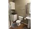 Bathroom with a white vanity, toilet, pedestal sink, shower, and a brown tiled floor at 1378 Runningbrook Dr, Avon, IN 46123