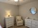Bedroom featuring neutral walls, a round mirror, a chair, and two dressers at 1378 Runningbrook Dr, Avon, IN 46123