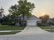Two-story home with brick and siding exterior, well-kept lawn, and mature trees under a golden sky at 1378 Runningbrook Dr, Avon, IN 46123