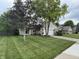 Beautifully landscaped front yard with lush green grass, mature trees, and a charming two-story home at 1378 Runningbrook Dr, Avon, IN 46123