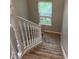 A carpeted stairway with white railing leads to the next level, illuminated by a window at 1378 Runningbrook Dr, Avon, IN 46123