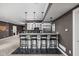 Basement bar area with pendant lighting, granite countertops, seating, and white cabinets with wine racks at 13888 Smokey Ridge Dr, Carmel, IN 46033