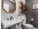 Chic powder room showcasing a designer mirror, vessel sink, and stylish patterned wallpaper at 13888 Smokey Ridge Dr, Carmel, IN 46033