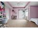 Bright pink bedroom featuring a desk, display cabinet, and a sliding barn door leading to the ensuite bathroom at 13888 Smokey Ridge Dr, Carmel, IN 46033