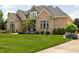 Stunning brick home with a lush green lawn and mature landscaping at 13888 Smokey Ridge Dr, Carmel, IN 46033