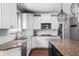 Well-appointed kitchen featuring granite countertops, white cabinetry, and a designer chandelier at 13888 Smokey Ridge Dr, Carmel, IN 46033