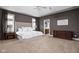 Spacious main bedroom with a tray ceiling, neutral carpet, and en-suite bathroom at 13888 Smokey Ridge Dr, Carmel, IN 46033