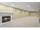 Finished basement with a cozy fireplace, neutral carpet, and ample open space at 13938 Charleswood Ct, Fishers, IN 46038