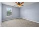Empty bedroom featuring a ceiling fan, window, and carpeted floor at 13938 Charleswood Ct, Fishers, IN 46038