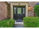 Close up of a front door with decorative glass and sidelights, framed by manicured shrubs at 13938 Charleswood Ct, Fishers, IN 46038
