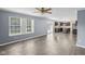 Open-concept living room with hardwood floors flowing into the kitchen with dark cabinets at 13938 Charleswood Ct, Fishers, IN 46038