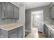 Classic kitchen featuring gray cabinets, neutral countertops, and easy access to the laundry area at 141 S 9Th Ave, Beech Grove, IN 46107